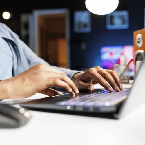 Remote tasks for company worker focusing on monthly earnings balance using legitimate financial details and web outputs. African american man manages his accounting tasks. Close up.